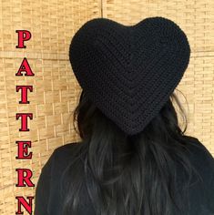 the back of a woman's head wearing a black crochet heart hat