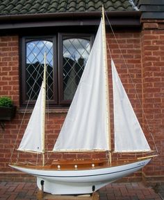 a model sailboat on display in front of a brick building