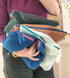 a woman holding several purses in her hands