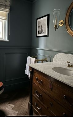 a bathroom with blue walls and wood floors