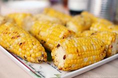 grilled corn on the cob sitting on a plate