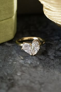 a heart shaped diamond ring sitting on top of a table