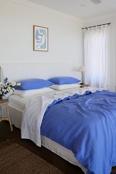 a bed with blue and white sheets in a bedroom