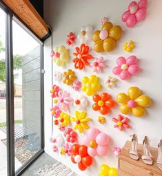 the wall is decorated with balloons and flowers