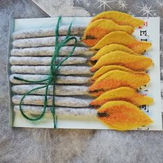 a bunch of orange and yellow flowers sitting on top of a piece of paper with green string