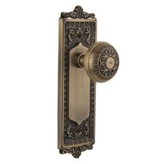 an antique style door handle with ornate design on the front and side panel, in bronze