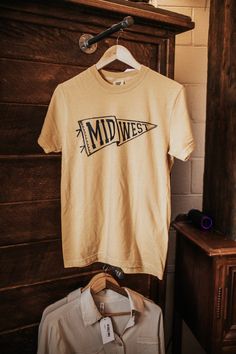 Love the midwest?! Personally, we think it's the best too! Represent the best of the west with this game day inspired graphic tee with black print and hand drawn team pennant. Black print reads "Midwest" Hand-drawn design Fit: True to Size - Unisex fit Round neck - mustard tee Fabric: 100% Cotton ©RusticHoney2024 Vintage Sports Shirt Design, Happy Tshirt Design, Simple Graphic Tees, Team Graphic Design, Retro Tshirt Design, T Shirt Typography, Camp Store, Best Graphic Tees, Vintage Tshirt Design