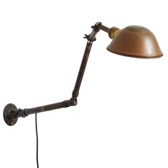 an old fashioned desk lamp with a metal shade on the arm and a cord attached to it