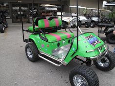 a green golf cart with pink and black stripes