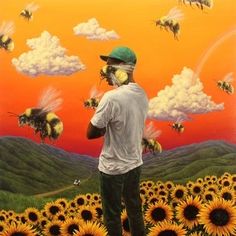 a man standing in front of a painting with bees on his face and the sun behind him