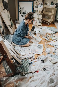 a woman is sitting on the floor painting