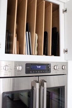 a stainless steel oven with wooden shelves above it