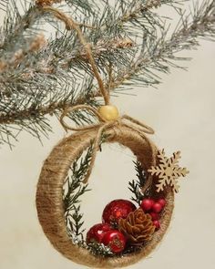 a christmas ornament hanging from a pine tree with ornaments on it's side