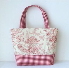 a red and white tote bag sitting on top of a table