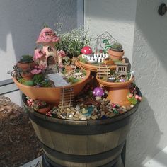 a potted planter filled with lots of different types of plants and decorations on top of rocks