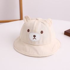 Get Ready for Adorable Adventures with Our Lovely Kids Bear Decor Panama Bucket Hat! Introducing our Kids Bear Decor Panama Bucket Hat a charming and practical addition to your little one's wardrobe. Crafted from a blend of soft cotton and durable polyester, this cartoon-themed Hat is designed to keep your child comfortable and stylish throughout the day. Product Features: Material: Cotton/Polyester blend Head circumference: Approximately 48CM Recommended age: Suitable for 6-24 months Top Type: Dome Feature: Multifunctional Applicable Scene: Casual Applicable Season: Four Seasons Gender: Unisex This adorable Hat features lovely bear ears that add a playful touch to your child's outfit. The breathable fabric ensures optimal comfort, making it ideal for outdoor adventures, picnics, beach day Playful White Adjustable Bucket Hat, Adjustable White Playful Bucket Hat, Cute Cream Hat For Gift, Playful White Hat With Adjustable Fit, White Playful Hat With Adjustable Fit, Playful Adjustable White Bucket Hat, White Bucket Hat For Playtime, Cute White Sun Hat For Playtime, Cute Cotton Bucket Hat