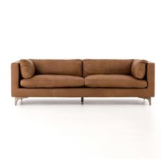 a brown couch sitting on top of a white floor