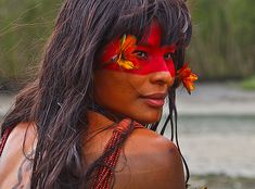 a woman with her face painted red and orange