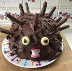 a cake with chocolate frosting and spiky eyes on it's face