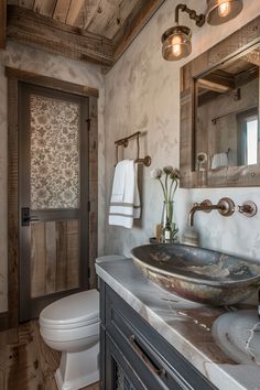 a bathroom with a sink, toilet and mirror on the wall next to a door