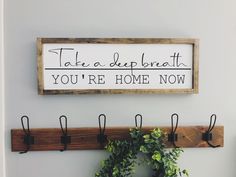 there is a sign that says take a deep breath you're home now on the wall