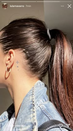 a woman with her hair in a ponytail and wearing a pair of ear piercings