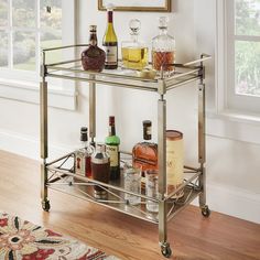 a bar cart with liquor bottles and glasses on it