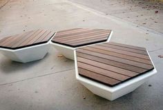 two white and brown benches sitting on the sidewalk