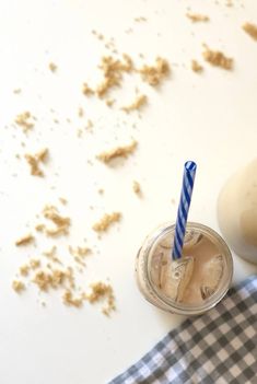 a drink with a straw in it sitting on a checkered napkin next to a bottle of milk