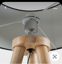 a wooden light fixture with a glass shade on the top and bottom part of it