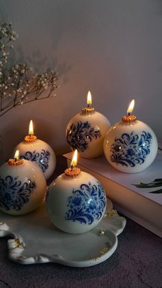 blue and white ornaments with candles on a plate