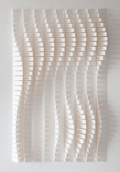 an art piece made out of white strips on a wall with no one in it