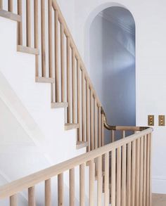 a wooden stair case next to a white wall