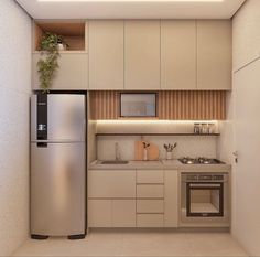 a small kitchen with stainless steel appliances and white cupboards, along with a plant on the wall