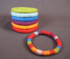 a stack of colorful bracelets sitting next to each other on top of a table