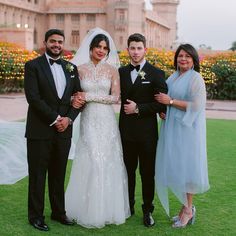 the bride and groom pose with their parents