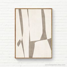 a white brick wall with an abstract painting hanging on it's side next to a wooden frame