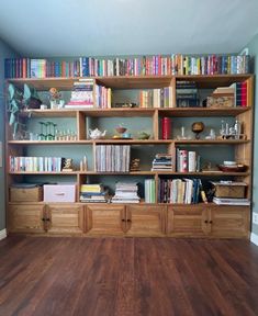 a bookshelf filled with lots of books on top of wooden shelves