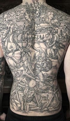 the back of a man with tattoos on his body