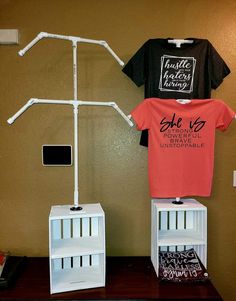 two t - shirts on display in front of a wall