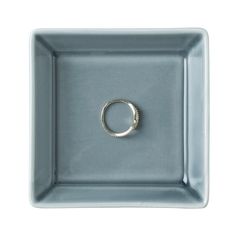 a ring sits in the middle of a square tray