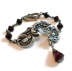 This lovely bracelet would be perfect for picnics in the graveyard or everyday wear! It's been created in a classic old school gothic style lovingly hand made by a genuine old school goth! ~ Detailed scroll element is antique silver plated brass ~ Vintage (1950's) Japanese dark garnet glass beads ~ Bracelet is adjustable from approx. 6 - 7 inches VEXED JEWELRY:  ONE-OF-A-KIND AND LIMITED EDITION SPOOKY HANDCRAFTED PIECES MADE WITH LOVE, SPITE, CARE, EXPERTISE & TOP QUALITY MATERIALS SINCE 2007! Dark Garnet, Victorian Bracelet, Gothic Bracelet, Beaded Rosary, Garnet Red, Gothic Victorian, Boot Jewelry, Rosary Bracelet, Brass Bracelet