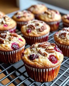 several muffins with cranberries and pecans sitting on a cooling rack