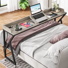 a laptop computer sitting on top of a bed next to a desk with a laptop