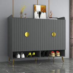 a grey cabinet with yellow handles and some shoes on the bottom shelf next to it