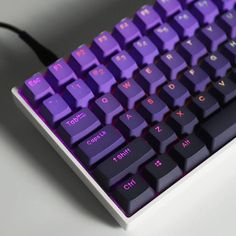 a purple keyboard sitting on top of a white table