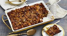 a casserole dish with pecans on top and two plates next to it