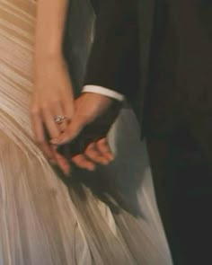 a man and woman in formal wear holding hands