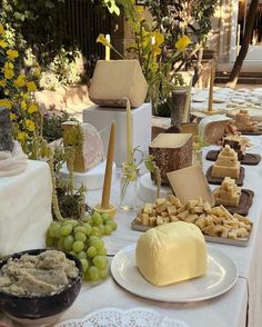 a table topped with lots of different types of cheeses and crackers on top of plates