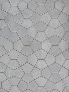 a close up view of a cement wall with hexagonal tiles on the floor